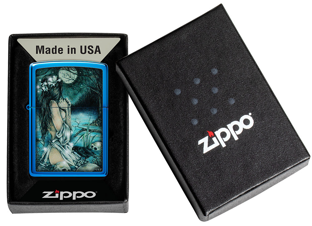 Encendedor Zippo azul brillante en un escenario místico con una dama ligeramente vestida en el lago rodeada de calaveras y cuervos en una caja abierta