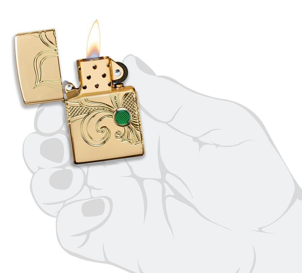 Briquet Zippo laiton haute brillance gravure profonde fleur de lis, ouvert avec flamme dans une main stylisée