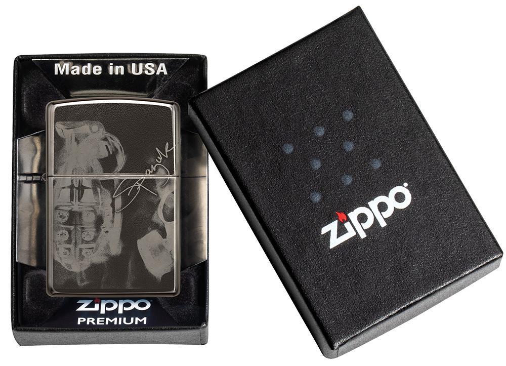 Vue de face briquet Zippo noir haute brillance avec motif de l'artiste Spazuk, dans une boîte cadeau ouverte
