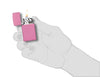 Briquet Zippo Slim Pink Matt, ouvert avec flamme dans une main stylisée