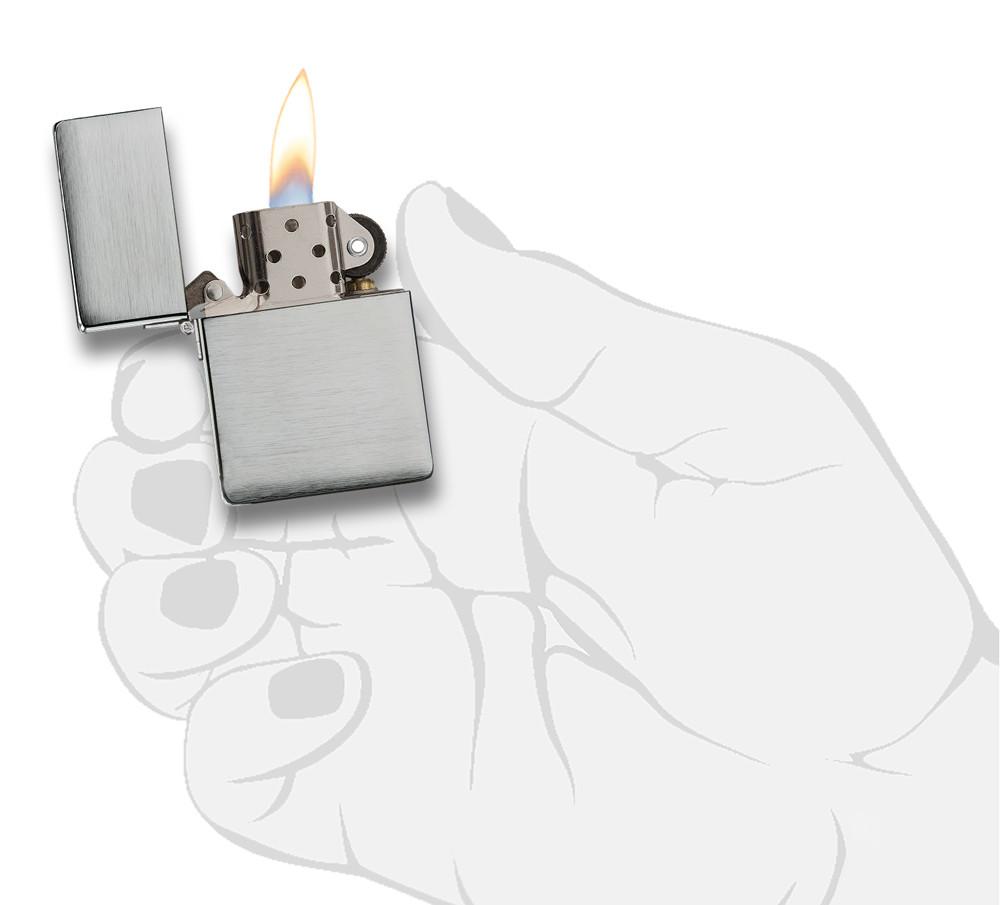 Réplica del encendedor Zippo 1935 vista frontal abierta y encendida en aspecto de cromo cepillado en mano estilizada