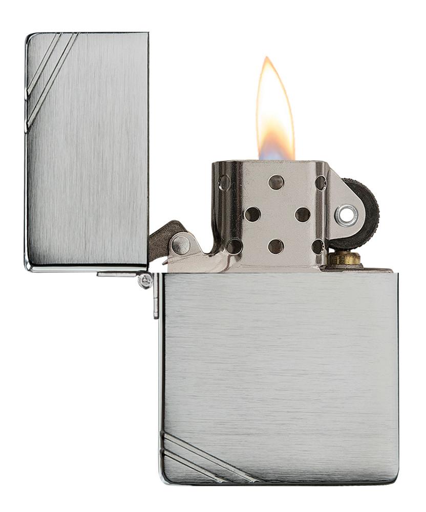 Réplica del encendedor Zippo 1935 vista frontal abierta y encendida en aspecto de cromo cepillado con barras grabadas en las esquinas opuestas.