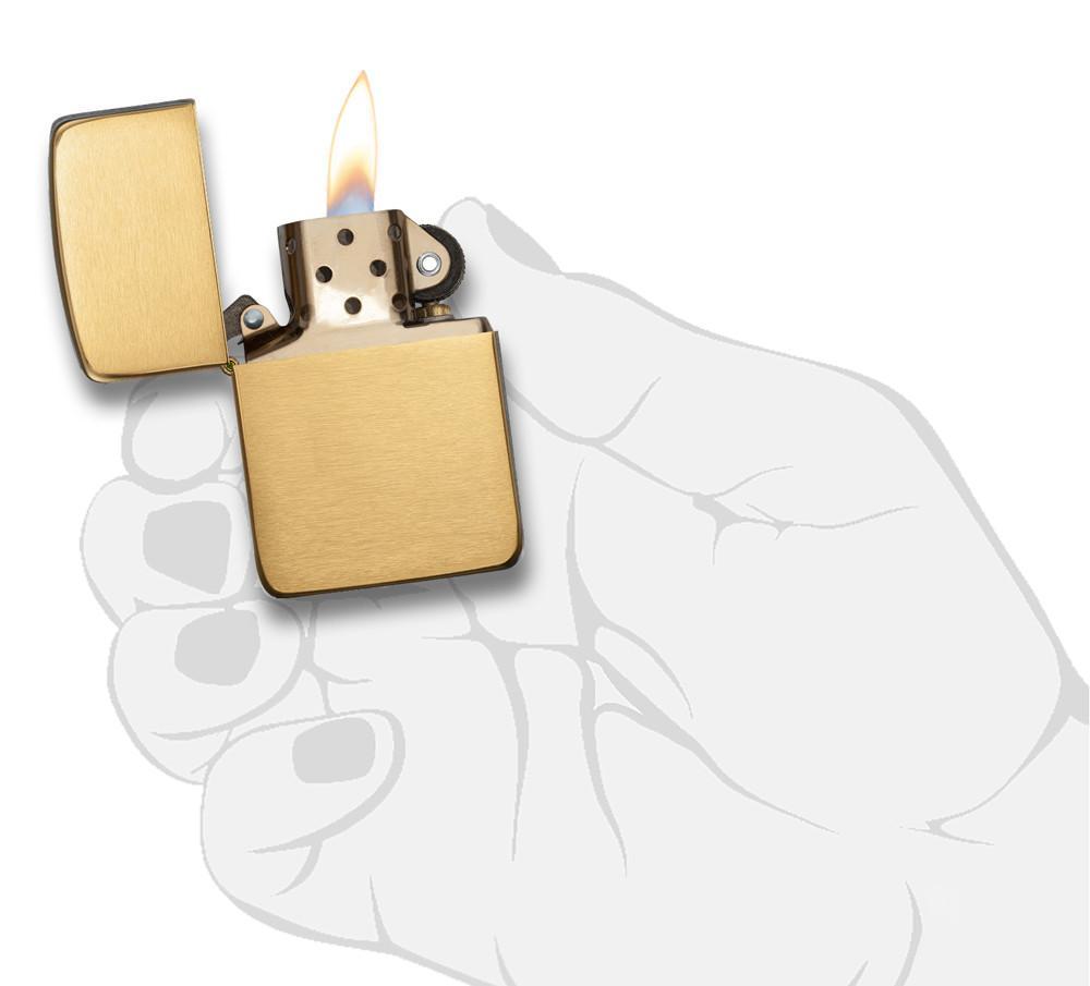 Réplica del encendedor Zippo 1941 vista frontal abierta y encendida en latón cepillado en oro en mano estilizada
