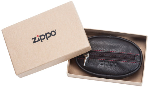 Petit porte-monnaie marron foncé fermé avec logo Zippo dans une boîte cadeau ouverte