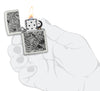 Encendedor Zippo vista frontal blanco mate abierto y encendido con la ilustración de una libélula en el estilo del arte aborigen en la mano estilizada