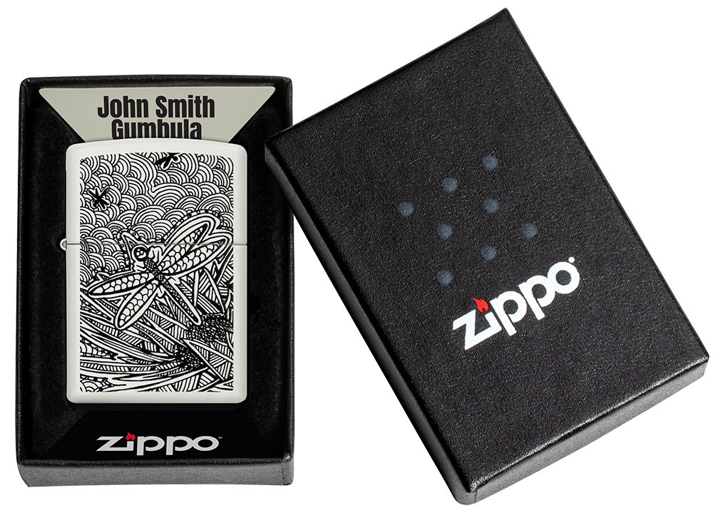 Encendedor Zippo vista frontal blanco mate con ilustración de una libélula en el estilo de arte aborigen en caja abierta