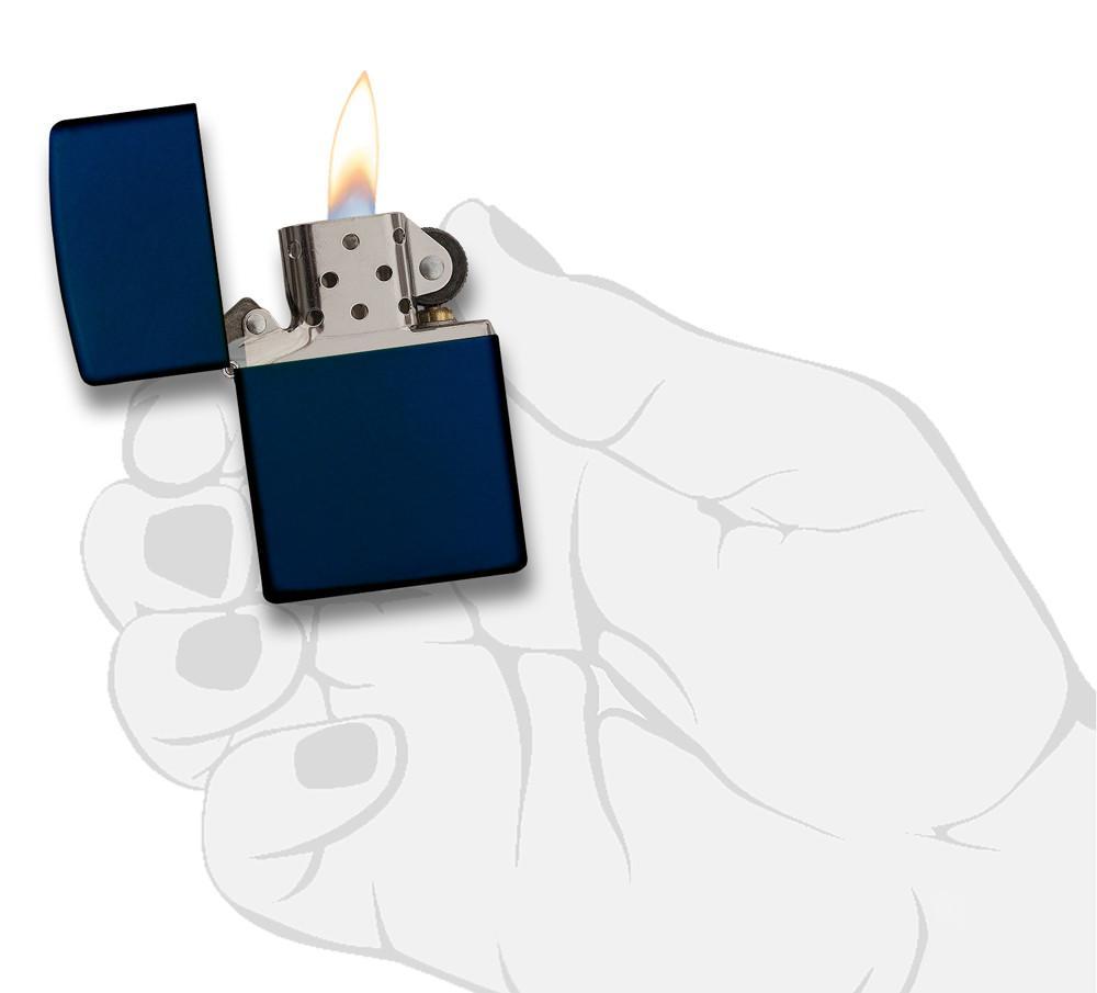 Vue de face briquet Zippo modèle de base Navy Blue Matte, ouvert avec flamme dans une main stylisée