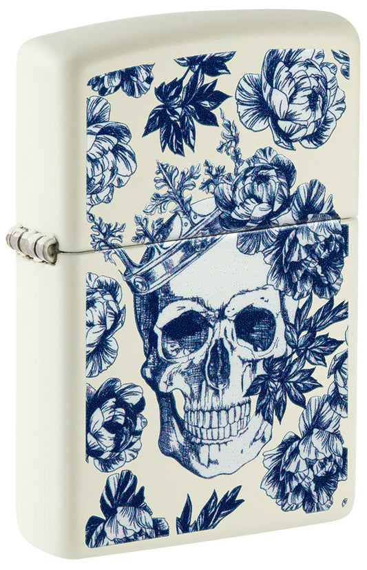 Encendedor Zippo vista frontal ¾ ángulo brilla en el cráneo oscuro con la corona rodeada de flores azules
