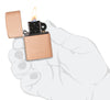Encendedor Zippo modelo básico en cobre macizo cepillado e inserto negro abierto con llama en mano estilizada