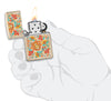 Encendedor Zippo color arena con estampado floral estilo hippie abierto con llama en mano estilizada