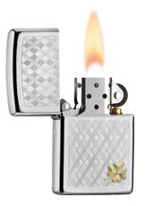 Vue de face briquet Zippo chromé à carreaux gravés avec un petit trèfle dans le coin inférieur droit, ouvert avec flamme