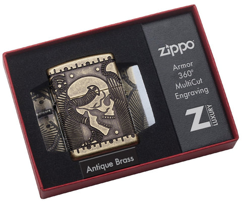 Briquet Zippo laiton antique avec gravure profonde tête de mort et éléMen,ts mécaniques, dans une boîte de luxe ouverte