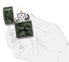 Mechero a prueba de viento Zippo Camo and Zippo Design en una mano para representar el tamaño del mechero