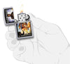 Briquet Zippo pochette Iron Maiden The Wicker Man, ouvert avec flamme dans une main stylisée