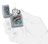 Briquet Zippo chromé style tatouage avec cœur, hirondelle et bannière Zippo, ouvert avec flamme dans une main stylisée