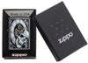 Briquet Zippo noir horloge d'où émerge une tête de mort avec des engrenages en arrière-plan, dans un coffret cadeau ouvert