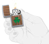  Zippo Woodchuck avec trèfle vert, ouvert avec flamme dans une main stylisée