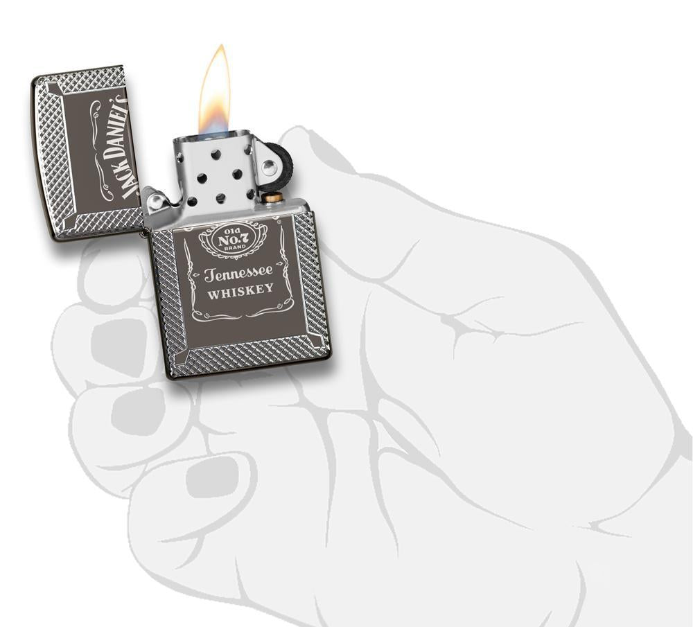 Briquet Zippo gris brillant logo et lettrage Jack Daniel gravés, ouvert avec flamme dans une main stylisée