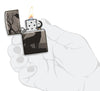 Briquet Zippo gris brillant loup hurlant à la lune dans la forêt motif à 360°, ouvert avec flamme dans une main stylisée