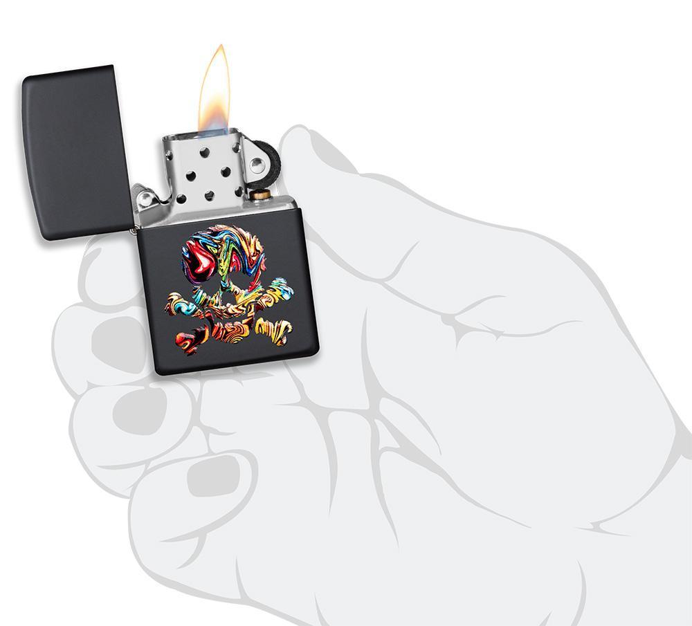 Briquet Zippo noir mat avec tête de mort multicolore, ouvert avec flamme dans une main stylisée