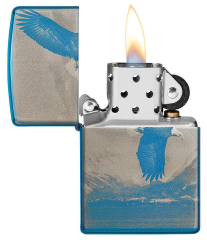 Vue de face briquet Zippo bleu haute brillance panorama de montagne avec aigle en vol, ouvert avec flamme