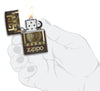 Mechero a prueba de viento Zippo Greek Key Design en una mano para representar el tamaño del mechero