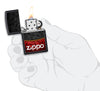 Mechero a prueba de viento Zippo Red Black Design en una mano para representar el tamaño del mechero