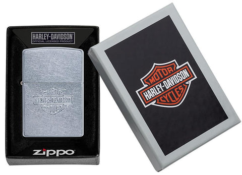 Vue de face briquet Zippo chromé avec logo Harley-Davidson dans une boîte en carton ouverte