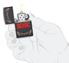 Vue de face briquet Zippo AC/DC noir mat, logo High Voltage Rock and Roll, ouvert avec flamme dans une main stylisée